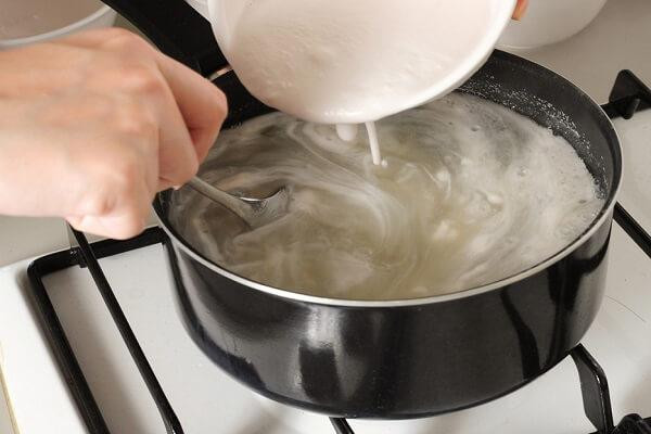 Cho bột gạo vào nồi lớn thêm nước, nước cốt dừa, nước vôi trong, muối, trộn đều lên. Sau đó bắt lên bếp đun với lửa nhỏ, vừa đun vừa khuấy khi nào bột sánh đặc lại thì tắt bếp. Ảnh: naucomngon.com.