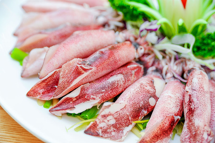 Bột đao cán nhỏ, mịn dùng làm bột áo. Mỡ khổ rửa sạch, luộc chín, thái hạt lựu. Trộn thịt giã nhuyễn với nấm, mộc nhĩ, mỡ khổ, miến, hành băm nhỏ, nước mắm cô đặc, mì chính, tiêu quật kỹ cho dẻo quánh, nhồi vào bụng mực, đem hấp chín. Ảnh: haisancoto.com.