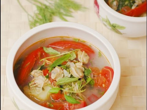 Cho dầu ăn vào nồi, phi thơm hành, cho cà chua cùng dứa vào đảo đều trong 2 phút. Cho nước luộc ngao vào đun sôi trong 5 phút. Thêm hạt nêm. Cho thịt ngao vào đun cùng. Nước sôi lại 2 phút là tắt bếp, thả rau răm cùng hành tươi vào. Ảnh: youtube.com.