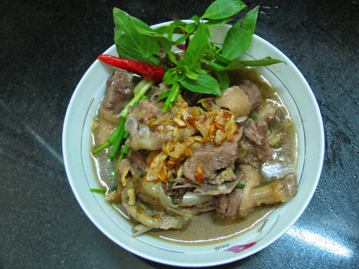 Khi nồi vịt om sấu sôi lại, thì thả phần sả còn lại cắt khúc dài chừng 4cm vào cho thơm. Ninh nhỏ lửa chừng 20 phút. Khi thấy sấu nhừ thì dầm nhuyễn sấu để phần thịt ngấm đủ vị của nước dùng. Ảnh: homnayangi.vn.
