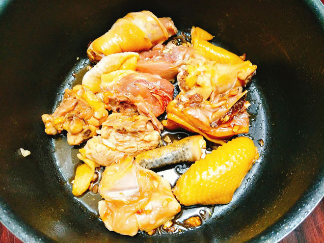 Cho một ít dầu ăn vào chảo đặt lên bếp, phi thơm tỏi băm, sau đó cho gừng thái sợi vào phi thơm sau đó cho gà vào đảo đều tay cho đến khi thịt gà chín. Ảnh: 24h.com.vn.