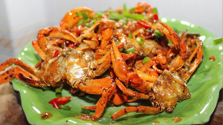 Nêm vào hạt nêm, bột ngọt, đường, rượu trắng, nước tương, tiêu bột sao cho vừa ăn; Tiếp tục đảo cua đều cho đến khi gần cạn nước là được. Cho phần hành lá thái mịn vào đảo vài lần nữa rồi tắt bếp. Ảnh: youtube.com.