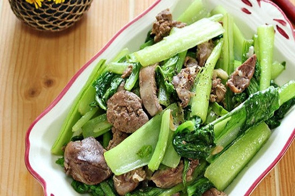 Phi thơm hành, gừng với chút dầu ăn, cho lòng gà vào xào chín tới rồi cho ra đĩa. Tiếp tục dùng chiếc chảo đó, thêm chút dầu rồi cho rau cải vào xào, Xào rau với lửa to để rau xanh màu. Để rau trên bếp khoảng 3 phút thì cho lòng gà vào, xào thêm 2 phút nữa thì nêm gia vị, rắc chút hạt tiêu rồi tắt bếp. Ảnh: JAMJA.vn.