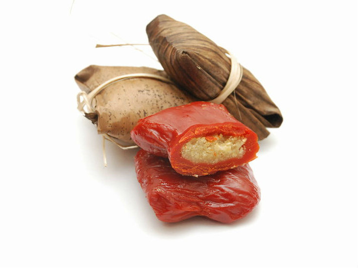 Chia đều nhân bột ra làm từng phần khoảng 1 muỗng canh, cho nhân đậu xanh, hạt sen, mứt bí, mỡ phần vào bao kín lấy phần bột, rắc ít mè lên. Đặt bánh lên lá chuối đã phết ít dầu ăn, gói lại, xếp mép lá kín, dàn đều 4 gốc, cho vào nồi luộc chín và thưởng thức. Ảnh: BepGiaDinh.com.