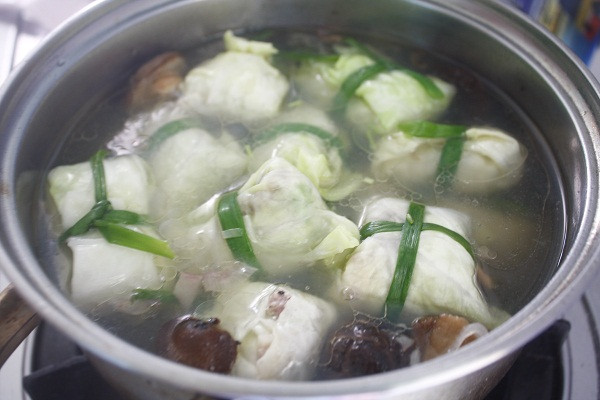 Hầm cuốn bắp cải nhồi thịt trong nước dùng khoảng nửa giờ cho chín mềm. Nêm vào nồi canh 1 thìa nhỏ muối, ít hạt nêm, nêm nếm tùy theo khẩu vị của bạn. Bắp cải mềm, múc ra bát dùng nóng, rắc hành lá đã thái nhỏ lên bề mặt bát canh. Ảnh: doisongphapluat.com.
