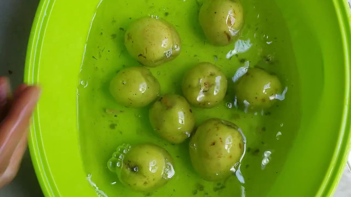 Dùng đĩa lớn đậy lên, đặt thêm một vật nặng lên trên như bát tô có chứa nước hay viên đá sạch, bịch nilon có nước (giống như nén dưa, cà khi muối); phủ lên trên toàn bộ các âu ngâm táo một khăn mỏng, sạch. Để nguyên khoảng 1 tuần. Ảnh: youtube.com.