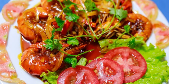 Đun sôi đến khi nước xốt me sánh đặc thì bạn nêm nếm lại tùy theo khẩu vị. Nhanh tay đổ tôm vào đảo cho nước xốt bám đều lên tôm. Thêm hành lá và rau ngò đã thái nhỏ vào đảo đều rồi tắt bếp. Lấy tôm ra đĩa, dùng nóng với cơm. Ảnh: ToiVaoBep.Org.