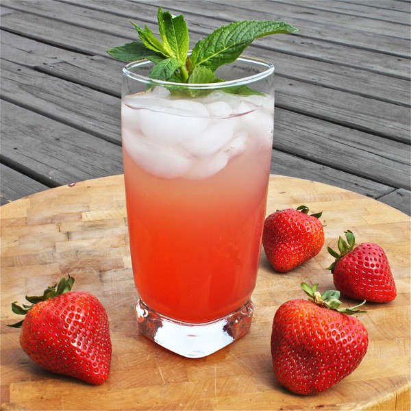 Khi đã xay dâu xong, lấy ly đá đã chuẩn bị sẵn cho soda vào nửa ly, cho chanh lát và dâu lát vào ly trang trí, tiếp đến là dâu xay cho lên mặt mỗi ly đá, rồi lại mỗi ly hai muỗng canh mật ong trang trí trên mặt cho đẹp rồi thưởng thức. Ảnh: kakihouse.vn.
