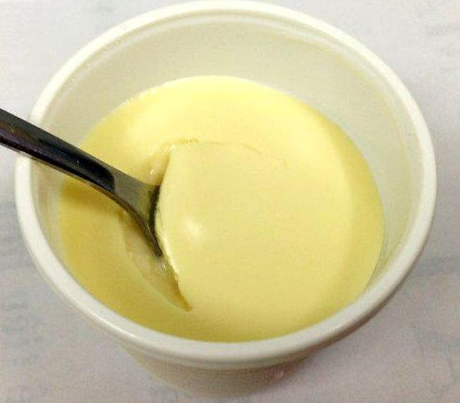 Dàn thật chặt hỗn hợp bánh quy bơ, càng chặt càng tốt, nhớ dàn đều rồi đặt cả khuôn và đế bánh vào tủ lạnh 20 phút. Phô mai đánh nhuyễn, mịn. Cho đường bột vào đánh cùng. Ảnh: Vntrip.vn.