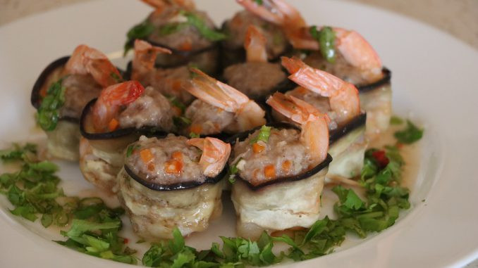 Sau khi các bạn cuộn cà tím với tôm thịt xong thì xếp vào đĩa mang cà tím cuộn tôm thịt đi hấp 30 phút là cà tím chín. Cà tím sau khi hấp xong lấy ra, chúng ta chan nước sốt lên trên và rắc thêm một ít hành và rau mùi cắt nhỏ lên trên. Ảnh: bepviet24.com.
