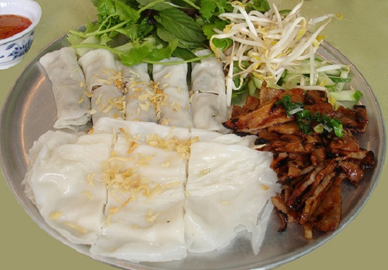 Đậy nắp hấp 2-3 phút là bánh chín. Dùng miếng tre mỏng nhúng nước lạnh nhẹ nhàng gỡ bánh ra, để lên dĩa, rồi tiếp tục đổ bột tráng tiếp bánh ướt. Bánh ướt hấp xếp lại cho ra dĩa có xà lách đồ chua, chả lụa rồi thưởng thức. Ảnh: 7monngonmoingay.info.