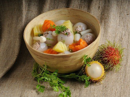 Bỏ các loại củ vào nồi nước dùng hầm vừa chín, cho chôm chôm nhồi thịt vào hầm thêm 10 phút, cho nấm kim châm vào 3 phút tắt bếp. Cho canh ra chén, rắc hành lá và ngò rí, thêm chút tiêu, có thể dùng chung với bún hoặc bánh mì đều được. Ảnh: bepgiadinh.com.
