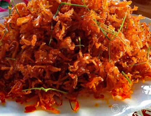 Xào thơm thì cho chén tương ớt, dừa khô và các gia vị vào xào 5-6 phút cho hỗn hợp hơi sánh. Cuối cùng cho lá chanh vào xóc đều 3-4 phút là tắt bếp. Ảnh: Zecook.vn.