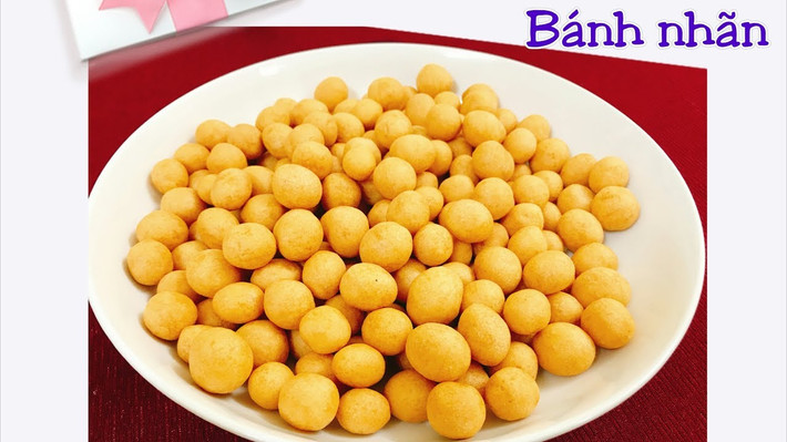 Đảo đều cho bánh chín đều. Đến khi bánh nở phồng và vớt bánh ra cắn thấy bánh xốp, khô, không còn bột ướt bên trong là đã chín. Cho đường vào đun với 15ml nước cho đến khi đường tan chảy. Nhanh tay cho bánh vào đảo đều cho đường phủ một lớp lên bánh. Đảo cho đến khi đường khô lại là được. Ảnh: youtube.com.