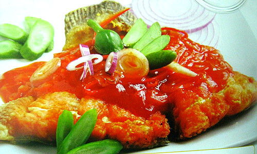 Lấy cá ra, cho hành tây vào đảo khoảng 2 phút, tiếp đến là nấm rơm 1 phút, cho cà chua vào, cho 2 hạt nêm, nước mắm, đường, đảo đều, để lửa nhỏ cho cà chua nhừ. Cho vào nửa chén nước, khuấy đều, đợi sôi lại nếm. Cho cá và, chút xíu tiêu xay, múc cá ra đĩa, ăn nóng cùng cơm trắng. Ảnh: cakholangvudai.org.