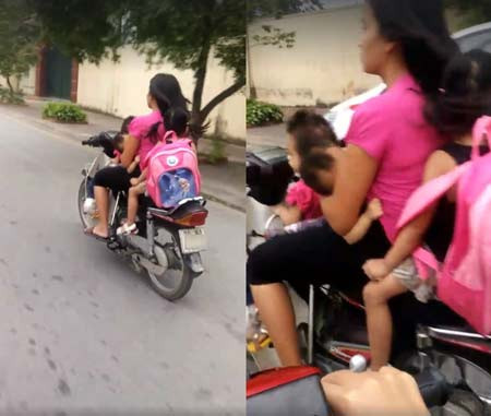 Bà mẹ vừa cho con bú vừa lái xe, đã không đội mũ bảo hiểm còn chở thêm 2 trẻ khác. Quá nguy hiểm. Ảnh: giadinh.net.vn.