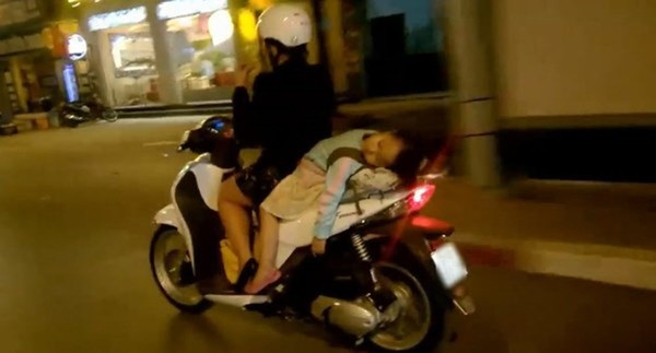 Em bé ngủ vô tư, còn bà mẹ thì vô tư lái xe. Ảnh: afamily.vn.