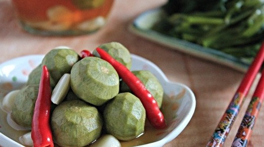 Xếp tỏi, ớt xen kẽ với sấu để đảm bảo các quả sấu đều ngấm vị cay. Tiếp theo, đổ nước mắm đã đun sôi để nguội vào, đậy kín nắp. Khoảng 3 ngày sau khi các gia vị ngấm đủ vào sấu là có thể ăn được. Ảnh: Cooky.vn.