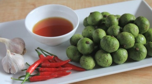 3. Sấu non ngâm mắm đường. Nguyên liệu: Sấu xanh, nước sôi, nước mắm, ớt, tỏi, đường, muối. Rửa sạch vỏ, sau đó cạo sạch lớp vỏ chát bên ngoài. Dùng dao sắc sạch khía sấu 3-4 cái để cho nước mắm ngấm nhanh và sâu hơn. Ảnh: doisongphapluat.com.