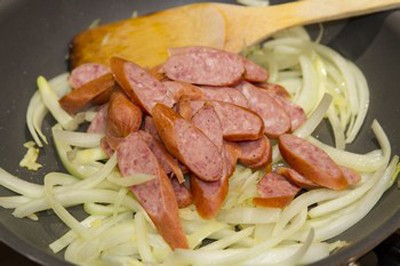Cho xúc xích vào xào sau khi phi thơm hành. Xúc xích hơi cong thì cho hành tây vào đảo. Nêm dầu hào và chút muối. Cho hành tây vào xào tới khi chín vừa ăn rồi tắt bếp. Ảnh: lamsao.com.