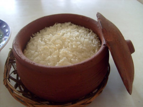 Sau đó, cho nước vào trong niêu và đun trên lửa hồng từ rơm rạ, củi khô, hoặc có thể dùng than để thay thế. Đợi đến khi nước sôi lên thì cho xửng gạo đã chuẩn bị trước đó vào và đậy nắp lại. Ảnh: amthuc.dendau.vn.