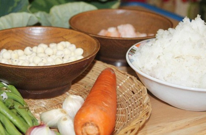 2. Cơm lá sen. Nguyên liệu: Gạo, hạt sen tươi, đậu Hà lan, cà rốt, nấm đông cô, thịt lợn nạc, tôm khô, lạp xưởng, lá sen tươi, tỏi, gia vị, cốm non. Gạo vo sạch, nấu thành cơm như bình thường. Ảnh: VnNgon.com.
