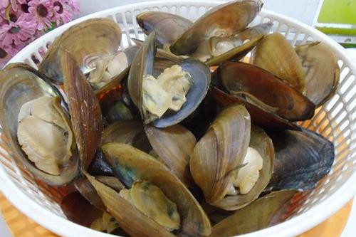 Trong khi chờ luộc trai ta nhặt rau rửa sạch, vớt ra rổ cho ráo, gừng cạo vỏ rửa sạch. Rau cắt nhỏ vừa ăn, ớt băm nhỏ bỏ hạt. Trai đã chín, Lấy đũa đảo đều và tách để riêng phần vỏ và nhân trai. Tách nhân trai để riêng. Ảnh: Nauanngonre.com.
