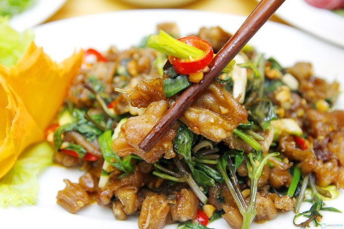 Bắc chảo lên bếp, đun nóng chảo, cho chút dầu ăn, đổ tỏi và sả vào phi thơm. Cho thịt vịt đã ướp sẵn vào xào săn. Thả lá lốt và húng quế vào, đảo cho rau chín tới và bắc ra là được. Ảnh: meovatdoisong.net.