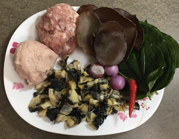 3. Ốc cuộn lá lốt áp chảo. Nguyên liệu: Ốc bươu, nghệ, tỏi, hành lá, sa tế, đường, dầu ăn, lá lốt. Cắt nhỏ ốc rồi, băm nhuyễn gia vị trộn cùng tất cả nguyên liệu trừ dầu ăn, để cho thấm khoảng 10 phút. Sau đó mới trộn đều dầu ăn. Ảnh: giadinh.net.vn.