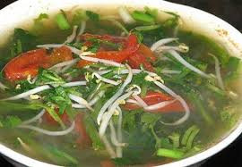 Đến khi nước sôi, lần lượt cho cà chua, rau giá, rau ngổ, hành tươi vào. Cho bát me đã dầm vào nồi, đợi đến khi sôi, nêm nếm gia vị lại đã phù hợp chưa thì tắt bếp. Ảnh: vaobepnauan.com.