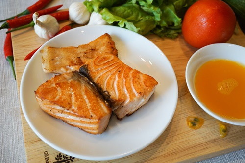 Cho cá hồi vào chảo chống dính, áp chảo cho chín đều 2 mặt. Dùng một cái chảo khác, cho tỏi vào phi thơm với bơ. Cho cá hồi ra đĩa rồi dội xốt bơ tỏi lên trên, rắc thêm hạt tiêu. Ảnh: mangdoisong.net.