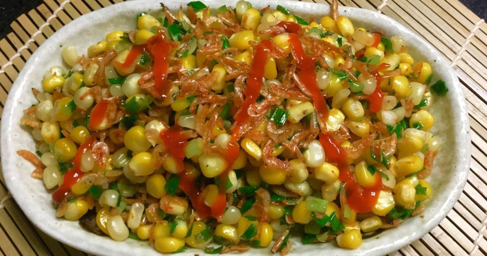 4. Bắp xào tôm khô, xúc xích. Nguyên liệu: Bắp ngô, hành tím, hành lá, xúc xích, tôm khô, nước mắm, đường, bơ. Phi thơm hành tím. Cho bắp ngô vào xào, thêm nước, xúc xích, tôm khô theo thứ tự rồi nêm gia vị, tắt bếp. Ảnh: cookpad.com.
