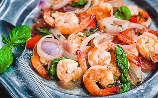 Cho rau húng quế thái nhỏ vào, kế đó, cho phần tôm xào sẵn vào đảo cùng cho đến khi tôm chín hẳn. Sau cùng mới cho rau húng để nguyên lá vào đảo lại trong giây lát rồi tắt bếp. Ảnh: Baophapluat.vn.