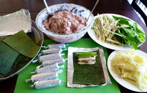 Đặt giấy bạc vào khuôn vuông. Tiếp đến, đặt lá lốt đã chuẩn bị vào khuôn giấy bạc. Tiếp đến, cho phần chả ốc đã ướp vào khuôn và gói chặt tay lại. Làm lần lượt cho tới khi hết các phần nguyên liệu. Ảnh: 24h.com.vn.