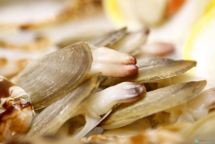 3. Tu hài sốt chua cay. Tu hài sau khi mua về, ngâm trong nước vo gạo để bớt vị mặn cũng như nhả hết bùn, đất, sau đó ngâm qua nước sôi hơi ấm để vỏ tu hài bớt vị mặn. Vớt ra rửa sạch lại và bắt đầu chế biến. Ảnh: baomoi.com.
