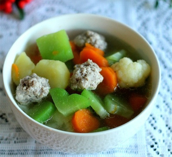 Cuối cùng thả bông cải, nêm vào nồi canh 1 muỗng nhỏ muối, hạt nêm, đường, đun nhỏ lửa cho rau củ thấm gia vị và tiết ra nước ngọt. Rau củ chín tới bạn tắt bếp, lấy canh thịt viên rau củ ra tô dùng nóng với cơm trắng rất ngon. Ảnh: NiemDamMe.com.