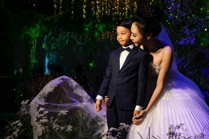 Đàm Thu Trang thể hiện sự yêu thương với con riêng của chồng khi liên tục ôm ấp, hôn má và nắm tay bé.