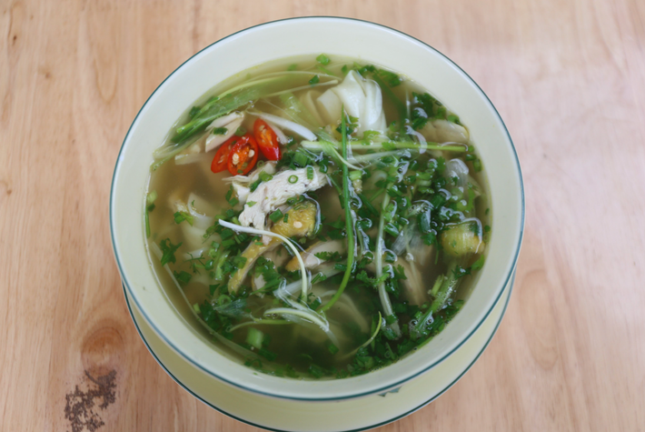 Trên đường từ thành phố Hà Giang lên cao nguyên đá. du khách sẽ có dịp dừng chân và thưởng thức món phở Tráng Kìm. Điểm độc đáo nhất của phở Tráng Kìm là bánh phở được chế biến hoàn toàn thủ công, sau khi chín sẽ đem phơi trên những thanh nứa bắt ngang trên nóc bếp, khi có khách ăn mới mang xuống thái thành sợi. Ảnh: Traveloka