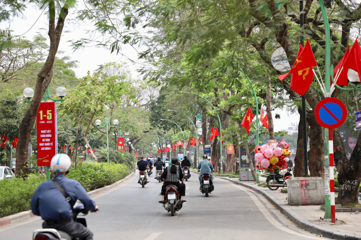 Cờ Tổ quốc, cờ Đảng, băng rôn được trang trí dọc 2 bên đường Thanh Niên.