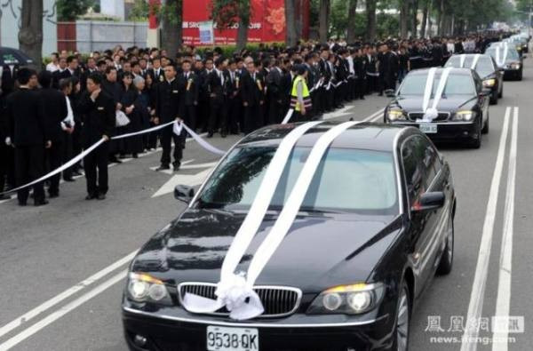 108 xe limousine màu đen dẫn đầu đoàn rước. Trong đạo Phật, 108 là con số tượng trưng cho sự thiêng liêng. Dàn người mẫu cầm biển đề tên các công ty đến viếng đi theo đoàn xe. Ảnh: ifeng.com