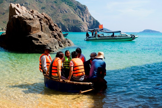 Ở bãi biển Kỳ Co, để ra được thuyền, du khách phải lên những chiếc thúng hoặc phà tự chế để ngư dân dầm mình trong nước kéo ra thuyền nằm cách 100 m. Ảnh: Nhi Nguyễn.