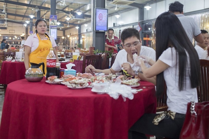 Hai người này không phải vợ chồng, không phải người yêu, thực chất đây là dịch vụ kỳ lạ: bóc ghẹ cho khách được cô gái này cung cấp