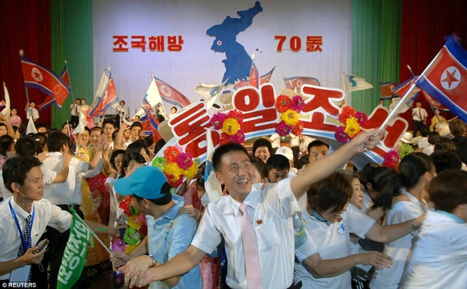 Người dân cầm cờ và hoa trong buổi lễ. Ảnh: Reuters.