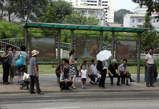 Người dân gồm người già và trẻ nhỏ chờ xe buýt tại một điểm đỗ ở thủ đô Triều Tiên. Ảnh: AP.