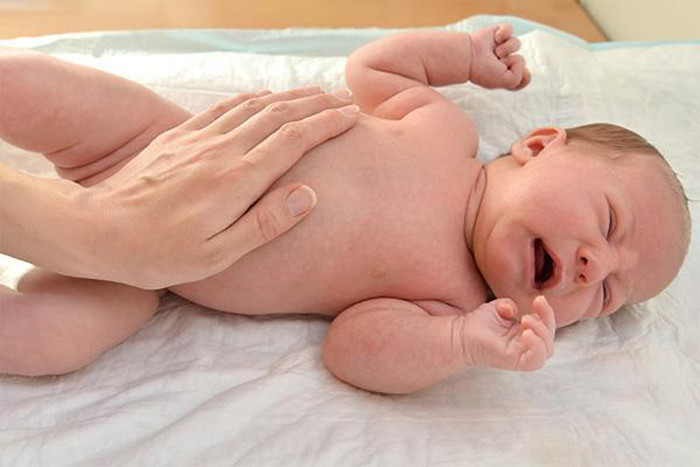 Tay ôm bụng. Những cơn khóc kéo dài, không rõ nguyên nhân của con khiến không ít bà mẹ lúng túng.