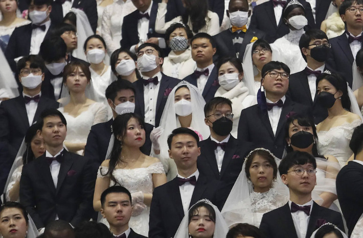 Mặc cho dịch virus corona đang hoành hành, hàng ngàn cặp đôi vẫn tổ chức đám cưới tập thể ở Nhà thờ Hợp Nhất (Unification), Hàn Quốc, hôm 7/2. Cô dâu, chú rể vẫn mặc trang phục cưới như bình thường, chỉ có khác là ai cũng đeo khẩu trang. (Nguồn ảnh: Guardian)