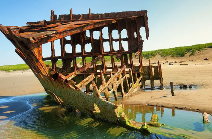 Xác tàu đắm Peter Iredale, một chiếc thuyền buồm bằng thép bị trôi dạt hơn 100 năm trước trên biển, hiện nằm trong công viên quốc gia Fort Stevens ở Oregon (Mỹ). (Nguồn ảnh: Insider)