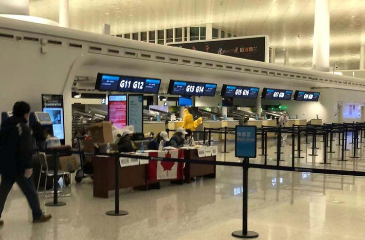 Các nhân viên sân bay đeo khẩu trang khi làm việc ở sân bay Vũ Hán để kiểm tra hành khách Canada sơ tán khỏi Vũ Hán.