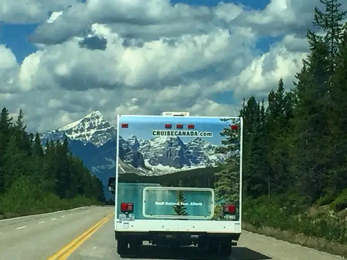 Một chiếc ô tô tải đi qua khu vực Icefields Parkway ở Canada đúng y khung cảnh trong bức hình quảng cáo phía sau xe.
