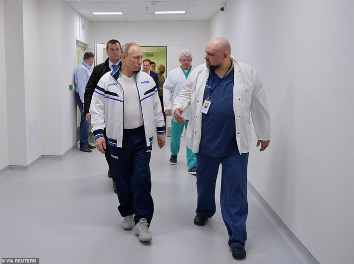 Ông Putin chụp ảnh cùng với bác sĩ trưởng của Bệnh viện Komunarka, Denis Protsenko. “Tôi quan sát họ làm việc. Tất cả các nhân viên y tế đang ở vị trí chiến đấu. Tôi không muốn dùng những sự diễn đạt mang tính chất quân sự này nhưng thực sự mọi thứ đang được tiến hành như một bộ máy khổng lồ” – Tổng thống Putin nói.